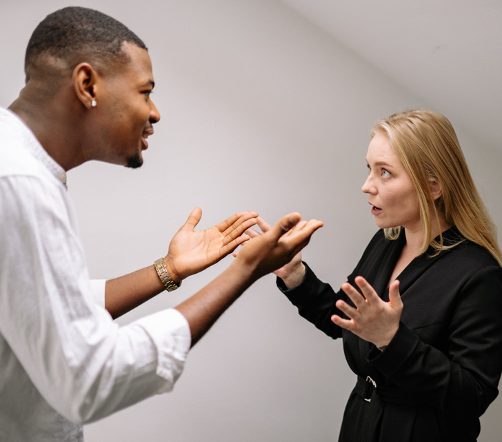 An interacial couple arguing, facing each other.